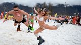 Ein russisches Pärchen springt in den Schnee.
