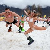 Ein russisches Pärchen springt in den Schnee.