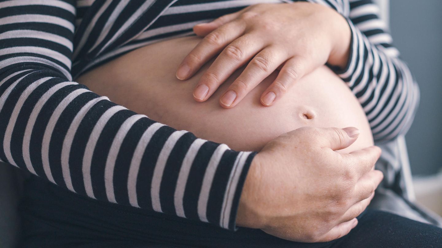 Eine schwangere Frau hält sich den Bauch