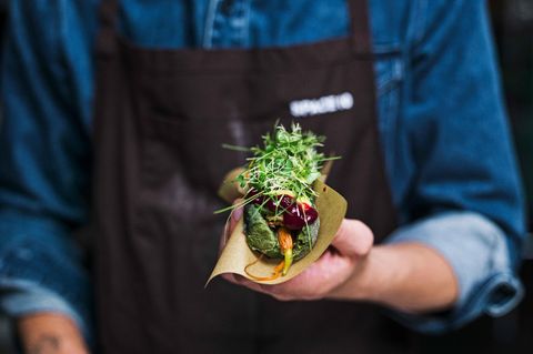Anstelle eines Würstchens sind im Hot-Dog-Brötchen getrocknete und glacierte Baby-Möhren, Bete- und Beeren-Ketchup, Senf, Kurkuma-Creme, geröstete Zwiebeln, Gurkensalat und ein Kräuter-Salat-Mix. 