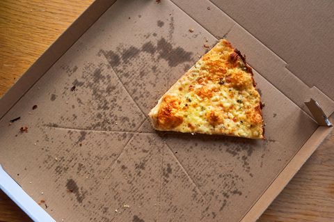 Pizzakarton mit einem Stück Pizza