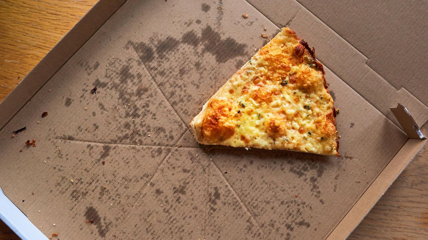 Pizzakarton mit einem Stück Pizza