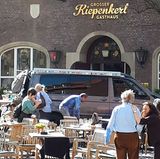 Menschen stehen vor einem der Lokale am Kiepenkerl, kurz nachdem ein Fahrzeug in das Straßencafe gefahren war.
