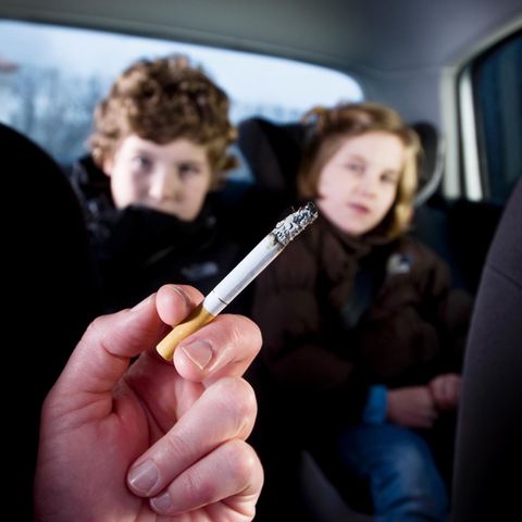 Rauchender Erwachsener mit Kindern im Auto