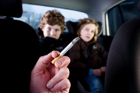 Rauchender Erwachsener mit Kindern im Auto