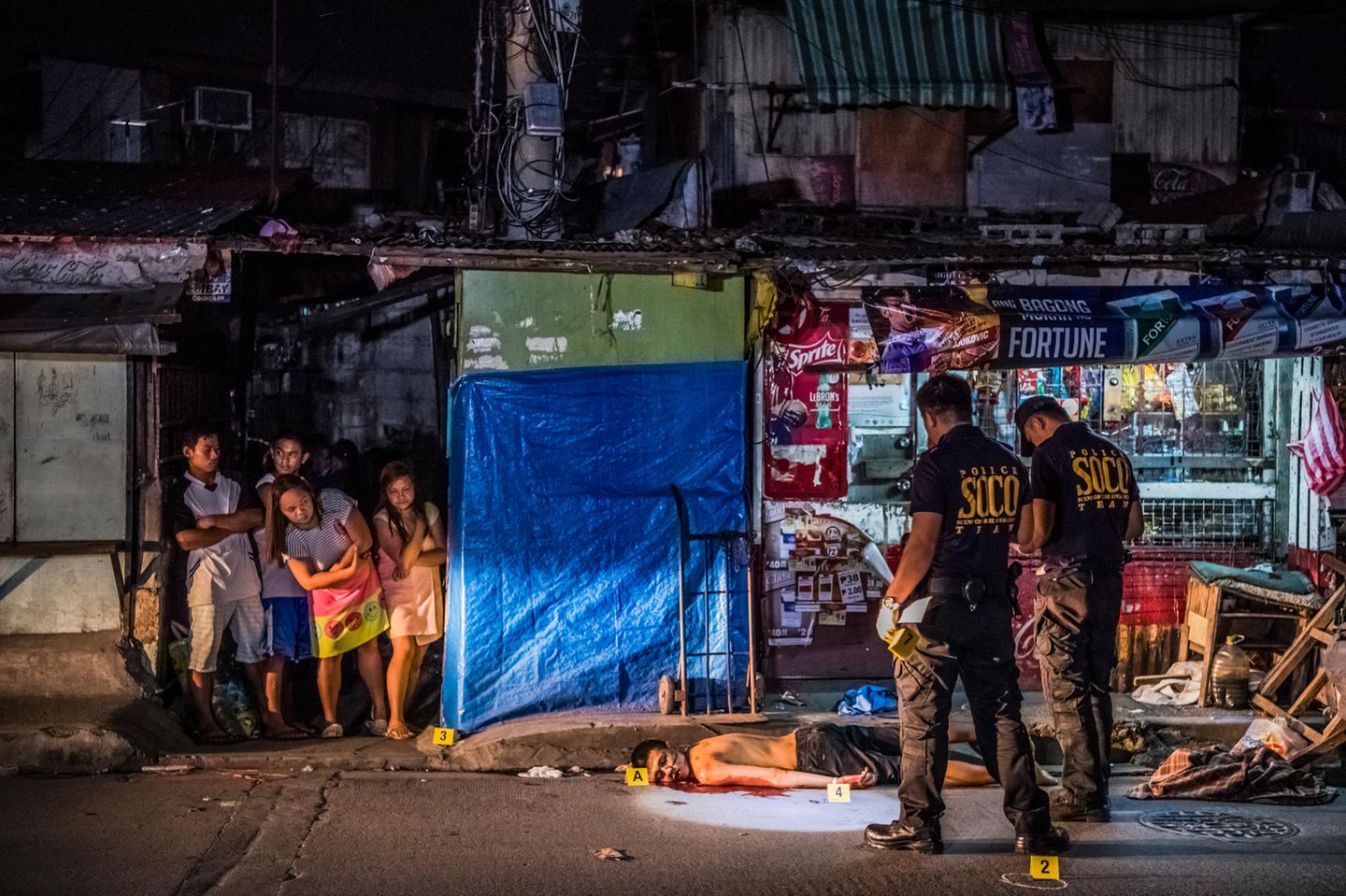 Fotoreportage: Beamte der Spurensicherung markieren den Tatort des Mordes an Michael Araja vor einem Laden im Pasay-Distrikt von Manila. Zeugen berichten, der 29-Jährige habe Zigaretten und etwas zu trinken kaufen wollen. Dann sei er von zwei Männern auf einem vorbeifahrenden Motorrad erschossen worden Beamte der Spurensicherung markieren den Tatort des Mordes an Michael Araja vor einem Laden im Pasay-Distrikt von Manila. Zeugen berichten, der 29-Jährige habe Zigaretten und etwas zu trinken kaufen wollen. Dann sei er von zwei Männern auf einem vorbeifahrenden Motorrad erschossen worden