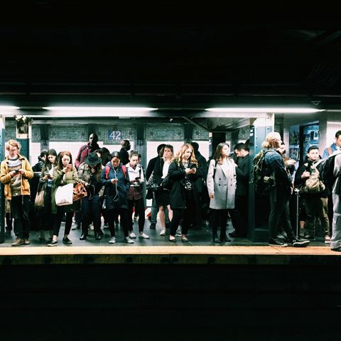 Menschen an Ubahnstation gucken aufs Handy
