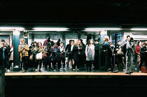Menschen an Ubahnstation gucken aufs Handy