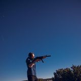 Joko-Reporter Friedemann Karig schießt mit einer Waffe im Freien.