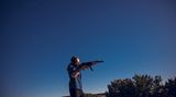 Joko-Reporter Friedemann Karig schießt mit einer Waffe im Freien.