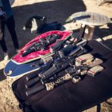 Sturmgewehre liegen auf einem Tisch im Freien.