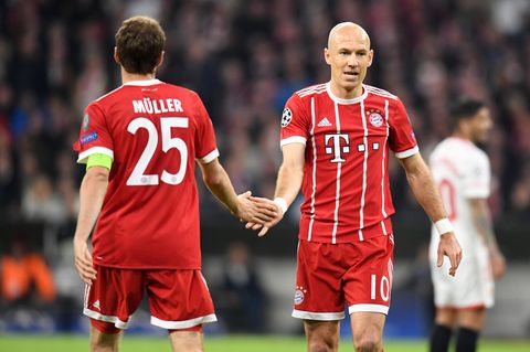 Thomas Müller und Arjen Robben vom FC Bayern München klatschen im Vorübergehen ab
