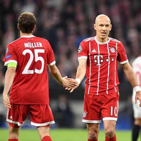 Thomas Müller und Arjen Robben vom FC Bayern München klatschen im Vorübergehen ab