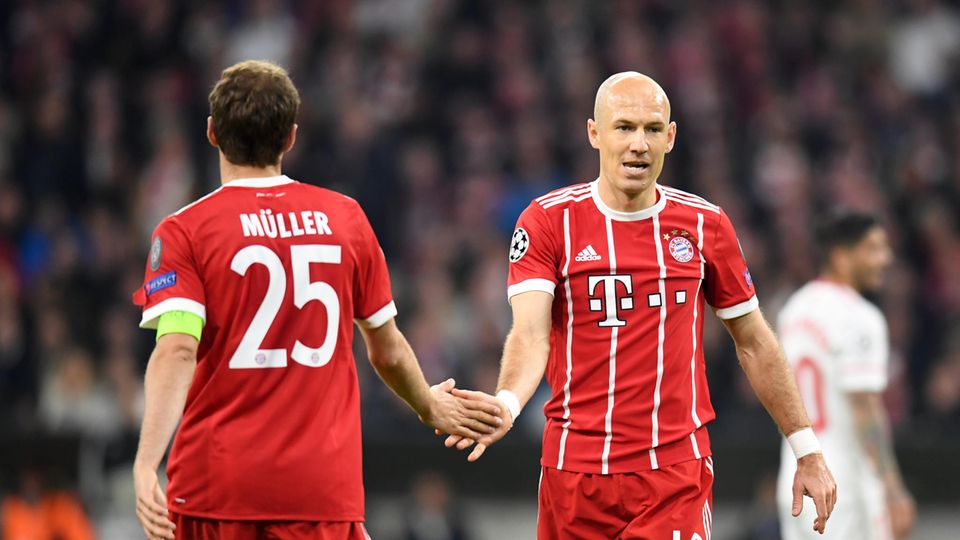 Thomas Müller und Arjen Robben vom FC Bayern München klatschen im Vorübergehen ab