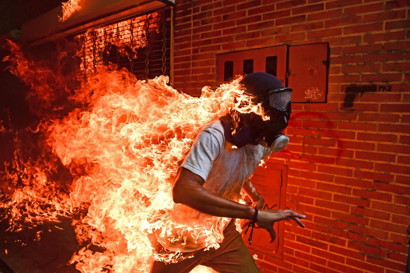 "Venezuela Krise" lautet der schlichte Titel des spektakulären Fotos, mit dem der Fotograf Ronaldo Schemidt jetzt den Titel für das Weltpressefoto des Jahres gewann. Das Bild zeigt den Demonstranten José Víctor Salazar Balza, der während der Proteste gegen Venezuelas Präsident Nicolás Maduro im Mai 2017 von Flammen erfasst worden war. Er überlebte mit schweren Brandwunden