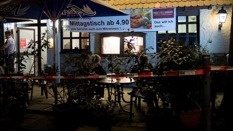 Köln: Polizisten stehen vor einem Restaurant. Im Keller hat die Polizei zwei Leichen gefunden.