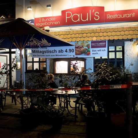 Köln: Polizisten stehen vor einem Restaurant. Im Keller hat die Polizei zwei Leichen gefunden.