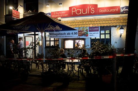 Köln: Polizisten stehen vor einem Restaurant. Im Keller hat die Polizei zwei Leichen gefunden.