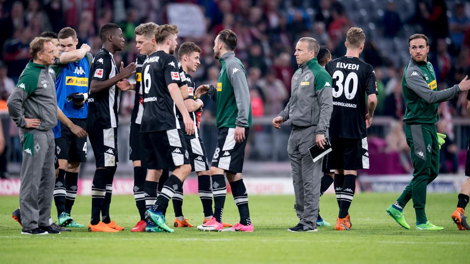 Nach Abpfiff  beim FC Bayern München stehen Spieler und Betreuer von Borussia Mönchengladbach mit hängenden Köpfen auf dem Rasen