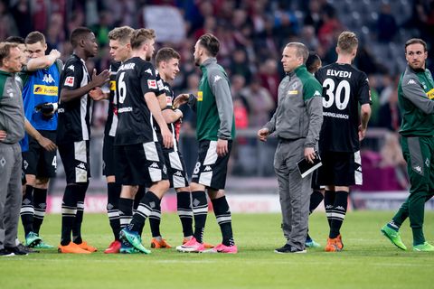 Nach Abpfiff  beim FC Bayern München stehen Spieler und Betreuer von Borussia Mönchengladbach mit hängenden Köpfen auf dem Rasen