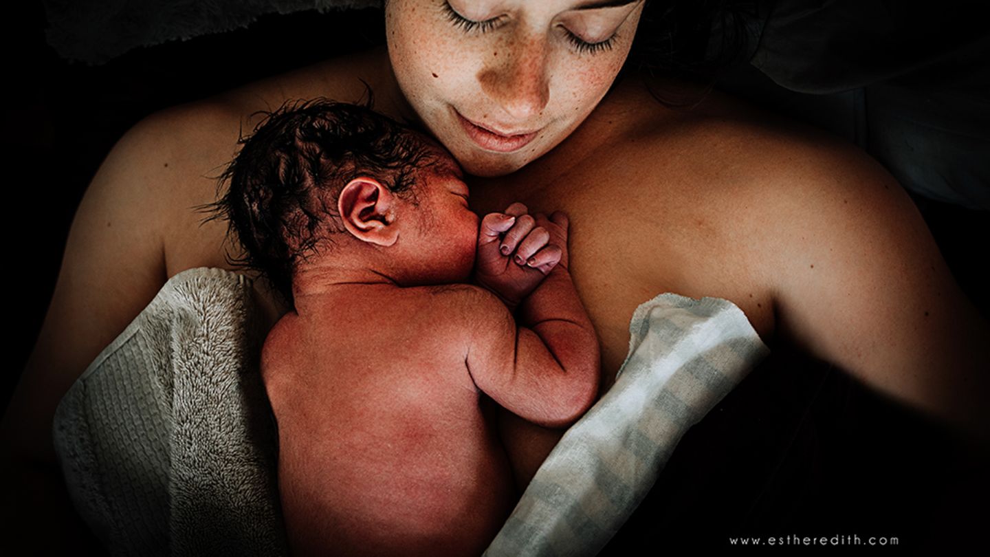 Frau mit ihrem Neugeborenen auf dem Wasserbett