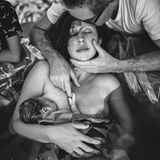 Frau mit frisch geborenem Kind in den Armen