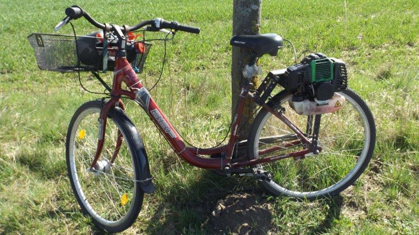 Ein Fahrrad mit einem anmontierten Rasenmähermotor.