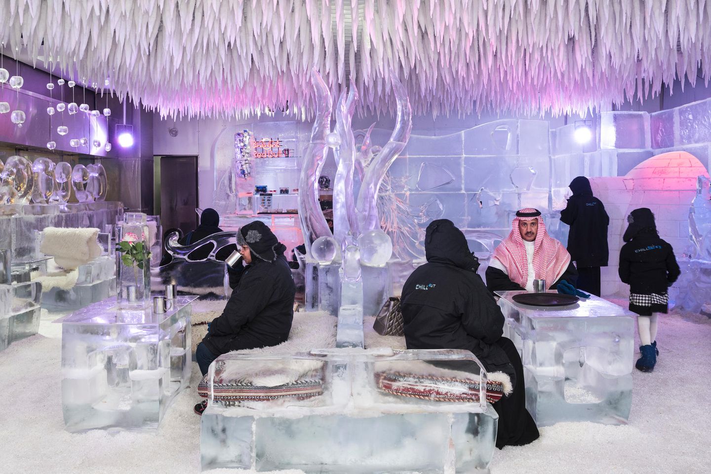 Saudi-Arabische Touristen sitzen in einer Eis-Lounge
