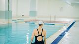 Frau sitztam Rand von Schwimmbecken