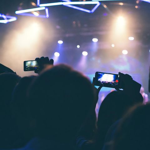 Auf einem Konzert halten Menschen ihre Smartphones in die Luft