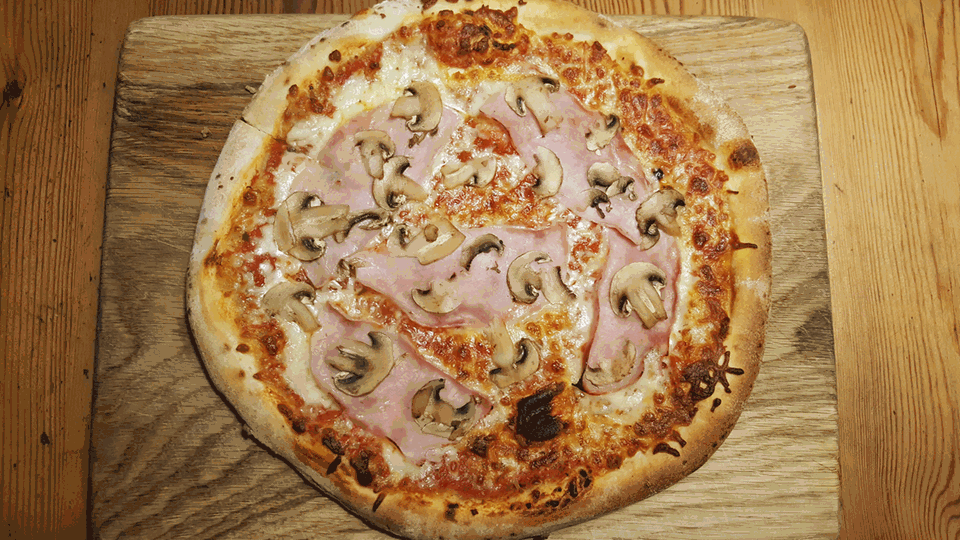 So sieht die Schinken-Pilze-Pizza nach dem Backen aus. Der Teig ist schön kross und nicht zu dick. Die Tomatensauce schmeckt gut. Der Belag ist ausbaufähig.
