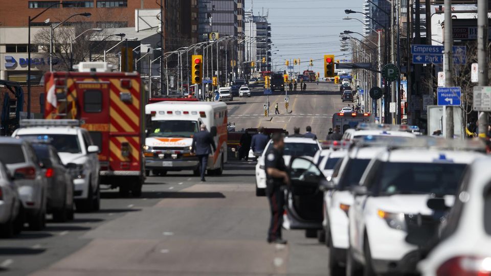 Polizei und Krankenwagen stehen in den der Straße, in der ein Mann mit einem Van mehrere Fußgänger überfahren hat