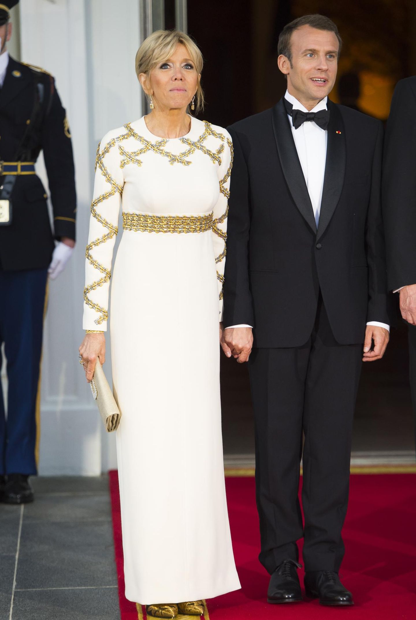 Brigitte Macron und Melania Trump Brigitte Macron blieb beim Altbewährten: Die Première Dame Frankreichs kleidete sich fürs Staatsbankett in eine weiß-goldene Robe von Louis Vuitton. Hingucker waren die goldenen Pumps, die unter dem langen Kleid hervorlugten.