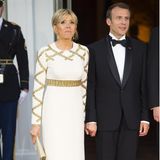 Brigitte Macron blieb beim Altbewährten: Die Première Dame Frankreichs kleidete sich fürs Staatsbankett in eine weiß-goldene Robe von Louis Vuitton. Hingucker waren die goldenen Pumps, die unter dem langen Kleid hervorlugten.