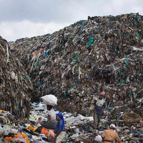 Menschen durchsuchen im Dandora Slum in Nairobi einen Müllberg nach wiederverwertbaren Gegenständen.