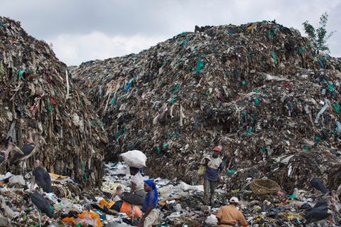 Menschen durchsuchen im Dandora Slum in Nairobi einen Müllberg nach wiederverwertbaren Gegenständen.