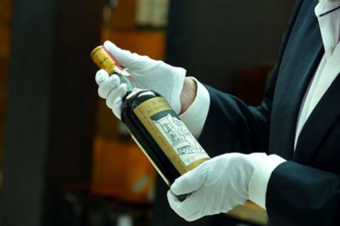 Mann inspiziert Flasche des Whiskeys The Macallan