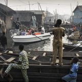 Fotograf: Jesco Denzel    24. Februar 2017    1. Preis im Segment "Einzelfotos"  Ein Boot mit Touristen wird durch die Makoko-Siedlung manövriert. Das frühere Fischerdorf am Ufer der Lagune von Lagos, Nigeria, hat sich zu einem enormen Wasser-Slum entwickelt.    Makoko hat rund 150.000 Einwohner, die meisten Familien leben hier schon seit Generationen. Aber Lagos wächst schnell, da ist Bauland sehr gefragt - und Luxusimmobilien am Ufer der Lagune sind begehrt. Darum versucht man, Gemeinschaften wie Makoko zu vertreiben, damit Apartments gebaut werden können: Wohnungen für die Reichen. Da die Regierung diese Gemeinschaften als informelle Siedlungen betrachtet, dürfen sie geräumt werden, ohne den Einwohnern einen Ersatz anzubieten. Durch die Vertreibung von der "Waterfront" verlieren sie ihre Existenz.