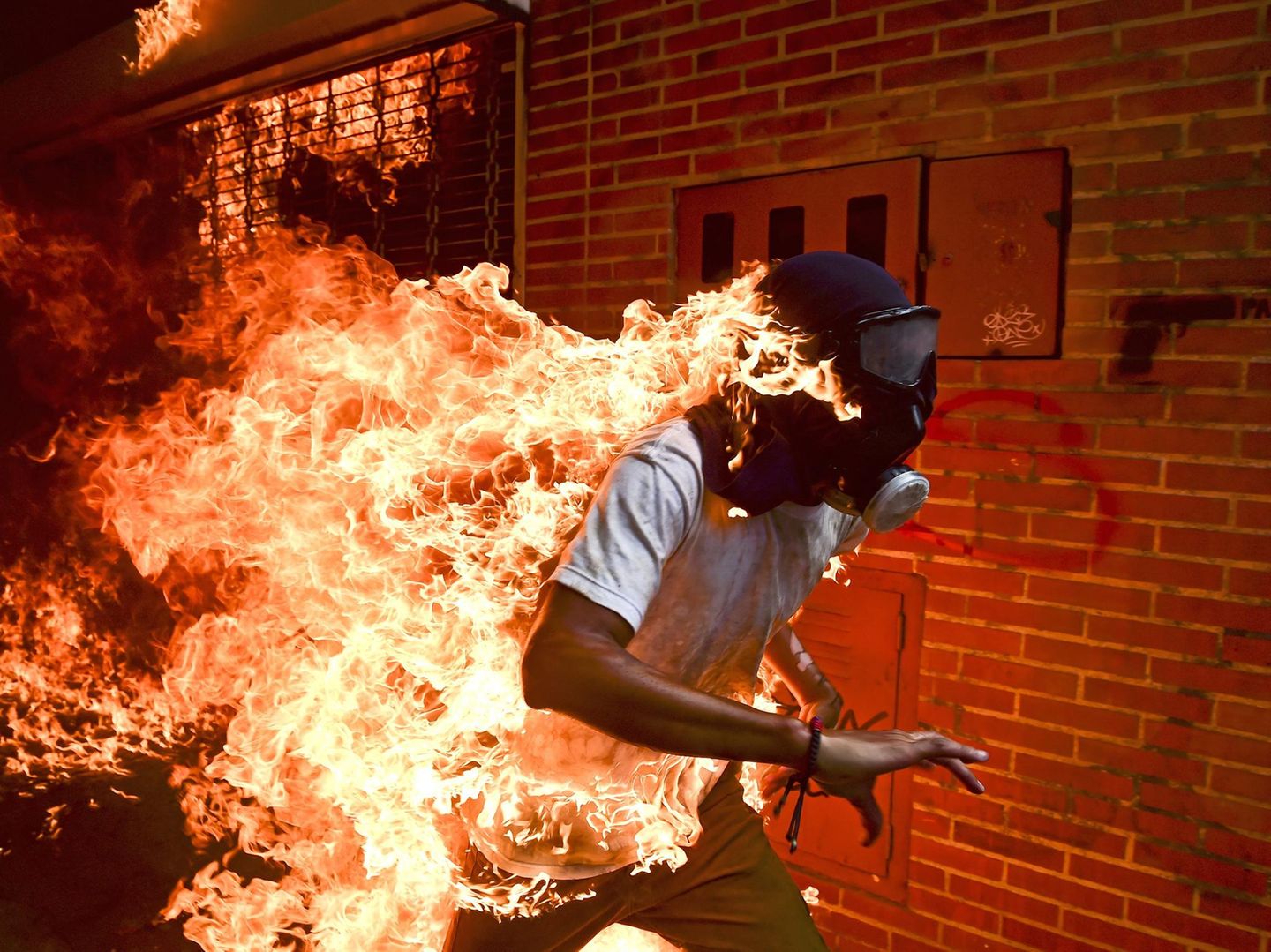 Ausgezeichnete Fotografie: Fotograf: Ronaldo Schemidt 3. Mai 2017 World Press Photo des Jahres 1. Preis im Segment "Einzelfotos" José Víctor Salazar Balza (28) gerät in Brand bei gewaltsamen Auseinandersetzungen mit der Bereitschaftspolizei, während einer Kundgebung gegen die vom Präsidenten Maduro angekündigte Reform der Staatsordnung, in Caracas, Venezuela. Maduro wollte das von der Opposition dominierte Parlament durch eine verfassunggebende Versammlung ersetzen und sich damit die gesetzgeberischen Befugnisse faktisch selbst sichern. Oppositionsführer riefen zu Massenprotesten auf, um vorgezogene Präsidentschaftswahlen zu verlangen. Am 3. Mai kam es zu Ausschreitungen zwischen Demonstranten und der Nationalgarde. Die Demonstranten (viele mit Kapuzen, Masken oder Gasmasken) zündeten Brandsätze an und warfen mit Steinen. Balza geriet in Brand, als der Tank eines Motorrads explodierte. Er überlebte mit Verbrennungen ersten und zweiten Grades. Fotograf: Ronaldo Schemidt 3. Mai 2017 World Press Photo des Jahres 1. Preis im Segment "Einzelfotos" José Víctor Salazar Balza (28) gerät in Brand bei gewaltsamen Auseinandersetzungen mit der Bereitschaftspolizei, während einer Kundgebung gegen die vom Präsidenten Maduro angekündigte Reform der Staatsordnung, in Caracas, Venezuela. Maduro wollte das von der Opposition dominierte Parlament durch eine verfassunggebende Versammlung ersetzen und sich damit die gesetzgeberischen Befugnisse faktisch selbst sichern. Oppositionsführer riefen zu Massenprotesten auf, um vorgezogene Präsidentschaftswahlen zu verlangen. Am 3. Mai kam es zu Ausschreitungen zwischen Demonstranten und der Nationalgarde. Die Demonstranten (viele mit Kapuzen, Masken oder Gasmasken) zündeten Brandsätze an und warfen mit Steinen. Balza geriet in Brand, als der Tank eines Motorrads explodierte. Er überlebte mit Verbrennungen ersten und zweiten Grades.