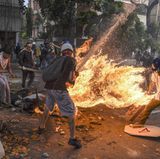 Fotograf: Juan Barreto    3. Mai 2017    3. Preis im Segment "Serien"  Bei Protesten gegen den venezolanischen Präsidenten Maduro gerät José Víctor Salazar Balza (28) in Brand, nachdem der Tank eines Motorrads explodiert ist.    Gewaltsame Ausschreitungen zwischen Demonstranten und der Nationalgarde waren ausgebrochen. Dem Anschein nach wurde das Motorrad eines Nationalgardisten von Demonstranten zerstört. Manchen der unterschiedlichen Berichte über den Vorfall zufolge löste ein von Demonstranten auf den Tank geworfenes Objekt die Explosion aus. Anderen Berichten zufolge fing Balzas Kleidung so leicht Feuer, weil diese durch einen von ihm selbst oder einem anderen Demonstranten mitgeführten Sprengsatz mit Benzin getränkt war.    Balza überlebte den Vorfall trotz schwerer Verbrennungen an über 70 Prozent seines Körpers.    Ein anderes Bild des brennenden Balza wurde zum World Press Photo 2018 gewählt. (Es ist Bild 1 dieser Fotostrecke.)