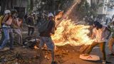 Fotograf: Juan Barreto    3. Mai 2017    3. Preis im Segment "Serien"  Bei Protesten gegen den venezolanischen Präsidenten Maduro gerät José Víctor Salazar Balza (28) in Brand, nachdem der Tank eines Motorrads explodiert ist.    Gewaltsame Ausschreitungen zwischen Demonstranten und der Nationalgarde waren ausgebrochen. Dem Anschein nach wurde das Motorrad eines Nationalgardisten von Demonstranten zerstört. Manchen der unterschiedlichen Berichte über den Vorfall zufolge löste ein von Demonstranten auf den Tank geworfenes Objekt die Explosion aus. Anderen Berichten zufolge fing Balzas Kleidung so leicht Feuer, weil diese durch einen von ihm selbst oder einem anderen Demonstranten mitgeführten Sprengsatz mit Benzin getränkt war.    Balza überlebte den Vorfall trotz schwerer Verbrennungen an über 70 Prozent seines Körpers.    Ein anderes Bild des brennenden Balza wurde zum World Press Photo 2018 gewählt. (Es ist Bild 1 dieser Fotostrecke.)