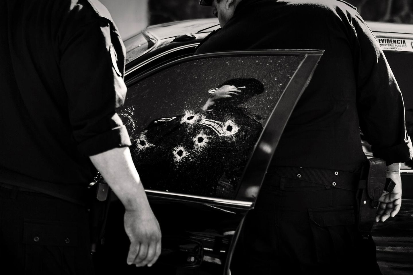 Fotograf: Javier Arcenillas     3. Preis     Viele Lateinamerikaner, die jahrelange Erfahrungen mit sozialem Chaos, Drogenhandel und politischer Korruption haben, wollen sich gegen die Gewalt wehren, von der ihre Länder betroffen sind. Nimmt man noch die Gewalt dazu, die mit dem Drogenhandel und mit dem "Krieg gegen Drogen" einherging, so gehören mehrere lateinamerikanische Städte zu den weltweit gewalttätigsten Städten außerhalb von Konfliktzonen.    Dieses Projekt beschreibt Angst, Wut und Machtlosigkeit der Opfer im täglichen Terror der maras (Straßenbanden) und anderer Formen der Gewalt in Honduras, El Salvador, Guatemala und Kolumbien, sowie die Entschlossenheit, dies zu beenden.    Die Polizei untersucht hier das Auto im noblen Hotel- und Ausgehviertel Zona Viva in Guatemala- Stadt, Guatemala, in dem die 31 Jahre alte Karina Marlene erschossen wurde ...