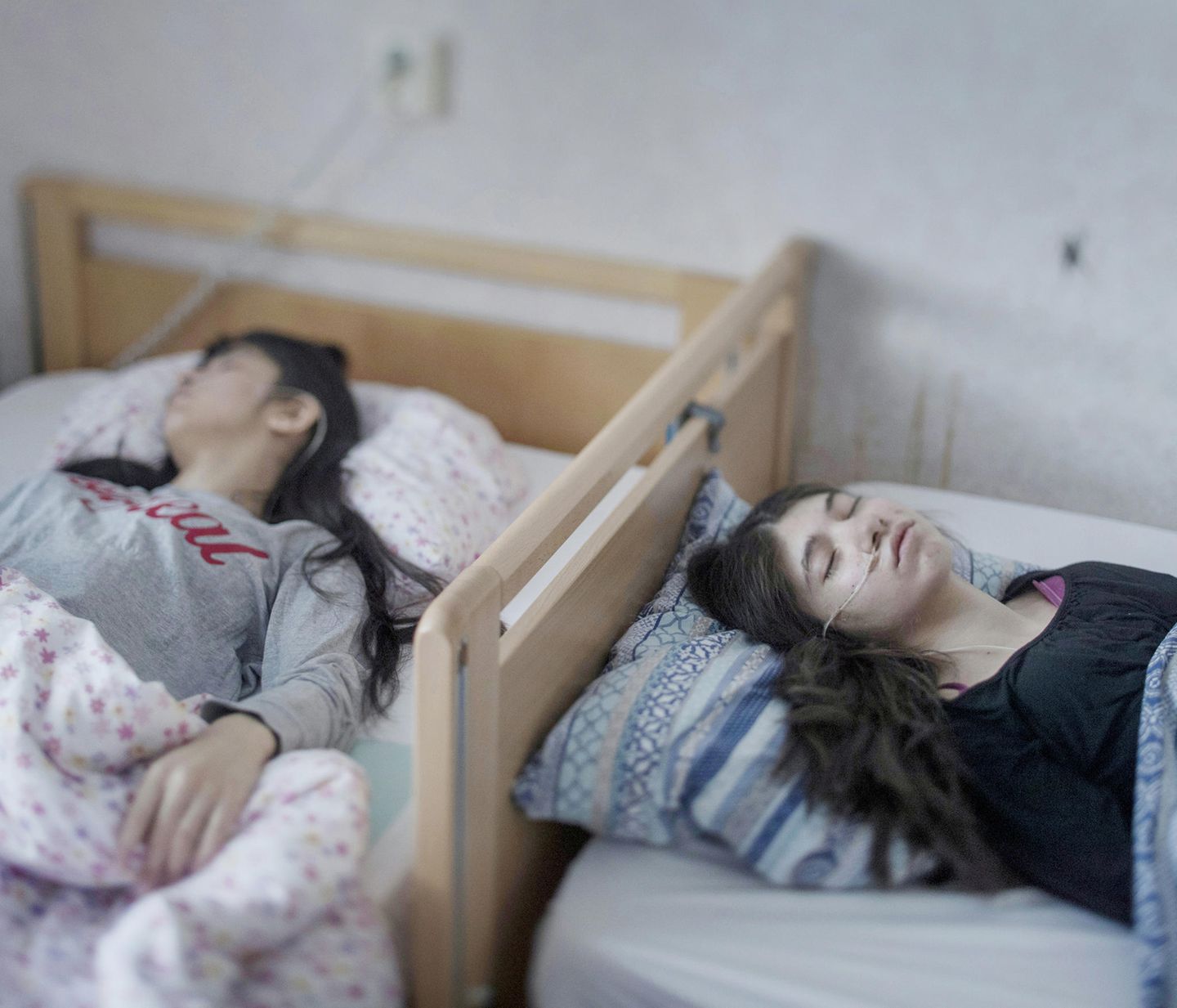 Ausgezeichnete Fotografie: Fotograf: Magnus Wennman 2. März 2017 1. Preis im Segment "Einzelfotos" Djeneta (rechts) liegt seit zweieinhalb Jahren in komaähnlichem Zustand im Bett, ihre Schwester Ibadeta seit über sechs Monaten. Sie leiden unter uppgivenhetssyndrom (Resignation Syndrome), in Horndal, Schweden. Djeneta und Ibadeta sind Roma-Flüchtlinge aus dem Kosovo. Am Resignation Syndrome (RS) Erkrankte sind passiv, unbeweglich, stumm, unfähig zu essen und zu trinken, inkontinent und reagieren nicht auf physische Reize. Die Erkrankung scheint nur unter Flüchtlingen in Schweden vorzukommen. Auch wenn die Ursachen rätselhaft sind, halten die meisten Fachleute ein Trauma für einen bedeutenden Auslöser, neben einer Reaktion auf Stress und Depression. Völlig unklar ist auch, warum solche Krankheitsfälle nur in Schweden auftreten. Bisher sind nur Flüchtlingskinder von 7 bis 19 Jahren, hauptsächlich aus der ehemaligen Sowjetunion und dem früheren Jugoslawien, von RS betroffen. Bei vielen trat das Syndrom nach der Ablehnung des Asylantrags auf. Als Heilmittel wird oft vorgeschlagen, den Familien der Erkrankten eine Aufenthaltsgenehmigung zu gewähren. Fotograf: Magnus Wennman 2. März 2017 1. Preis im Segment "Einzelfotos" Djeneta (rechts) liegt seit zweieinhalb Jahren in komaähnlichem Zustand im Bett, ihre Schwester Ibadeta seit über sechs Monaten. Sie leiden unter uppgivenhetssyndrom (Resignation Syndrome), in Horndal, Schweden. Djeneta und Ibadeta sind Roma-Flüchtlinge aus dem Kosovo. Am Resignation Syndrome (RS) Erkrankte sind passiv, unbeweglich, stumm, unfähig zu essen und zu trinken, inkontinent und reagieren nicht auf physische Reize. Die Erkrankung scheint nur unter Flüchtlingen in Schweden vorzukommen. Auch wenn die Ursachen rätselhaft sind, halten die meisten Fachleute ein Trauma für einen bedeutenden Auslöser, neben einer Reaktion auf Stress und Depression. Völlig unklar ist auch, warum solche Krankheitsfälle nur in Schweden auftreten. Bisher sind nur Flüchtlingskinder von 7 bis 19 Jahren, hauptsächlich aus der ehemaligen Sowjetunion und dem früheren Jugoslawien, von RS betroffen. Bei vielen trat das Syndrom nach der Ablehnung des Asylantrags auf. Als Heilmittel wird oft vorgeschlagen, den Familien der Erkrankten eine Aufenthaltsgenehmigung zu gewähren.