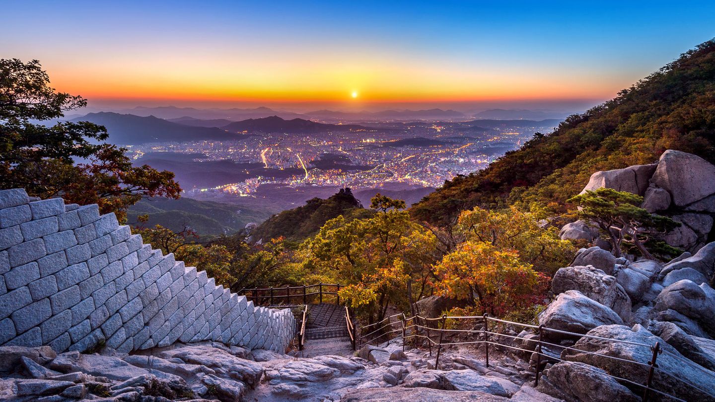 Wandern ist in Südkorea Volksport Nummer ein: Sonnenaufgang am Baegundae Peak and Bukhansan-Nationalpark Mountain mit Seoul im Hintergrund.