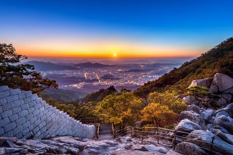 Wandern ist in Südkorea Volksport Nummer ein: Sonnenaufgang am Baegundae Peak and Bukhansan-Nationalpark Mountain mit Seoul im Hintergrund.