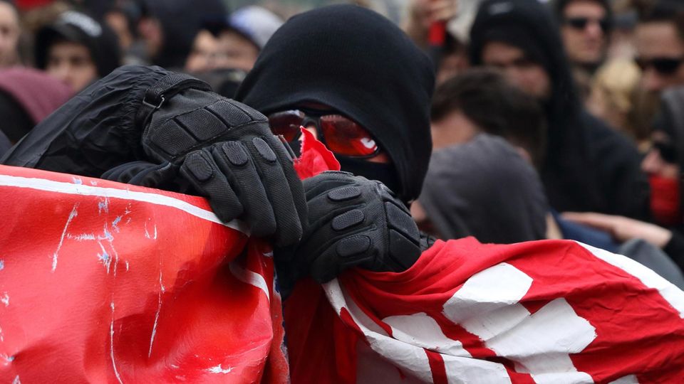 Vermummter Demonstrant mit schwarzem Kapuzenpulli am 1. Mai