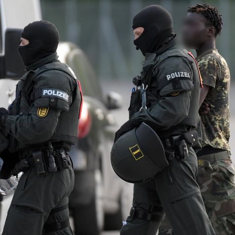Polizisten eskortieren einen Togolesen nach dessen gescheiterter Abschiebung aus der Flüchtlingsunterkunft in Ellwangen
