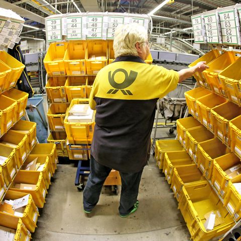 Eine Mitarbeiterin der Deutschen Post sortiert Großbriefe in einem Briefzentrum