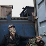 Zuch sitzt in einem Deepwell-Güterzuganhänger. Neben den geladenen Containern finden sich ein paar Meter Platz um es sich gemütlich zu machen und unbemerkt mitzufahren.