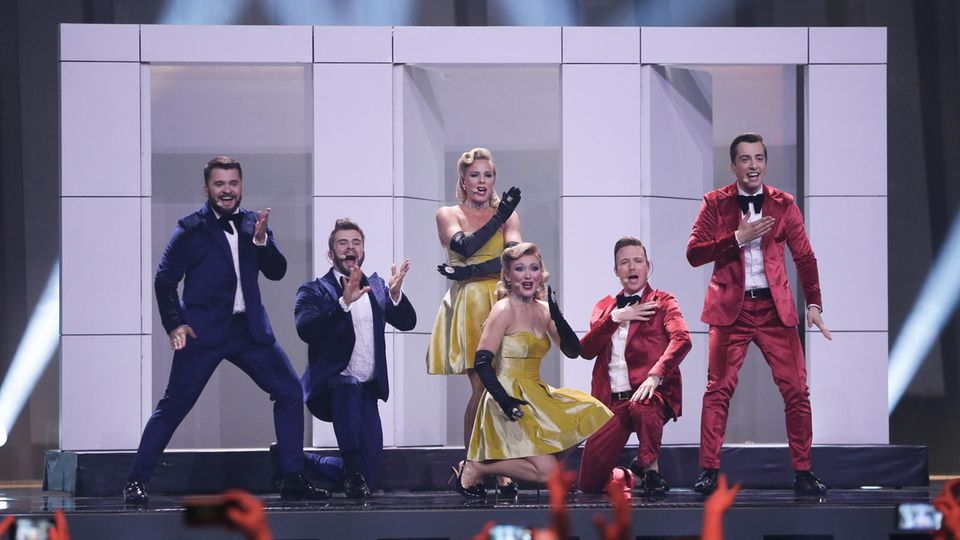In blauen oder roten Anzügen und gelben Kleidern stehen die sechs Mitglieder von DoReDos aus Moldawien auf der ESC-Bühne